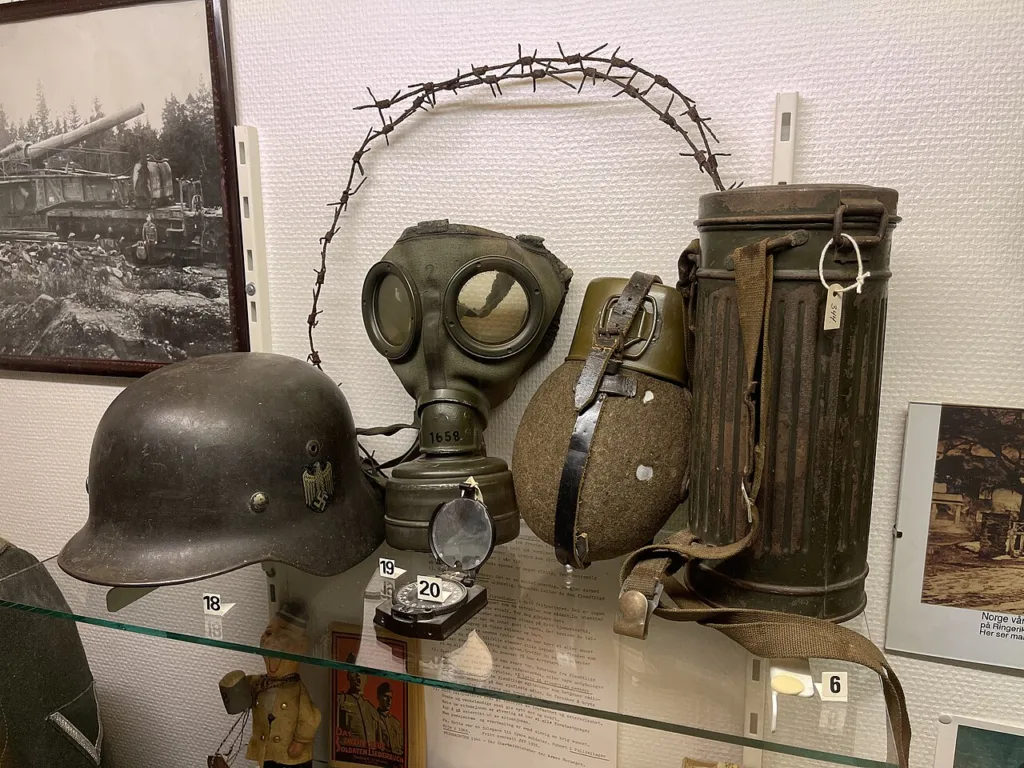German WW2 helmet, gas mask, gas mask canister and canteen in a museum display