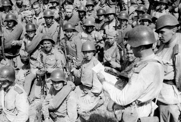 Soviet soldiers in SSh-40 helmets reading a leaflet before an attack, September 1943